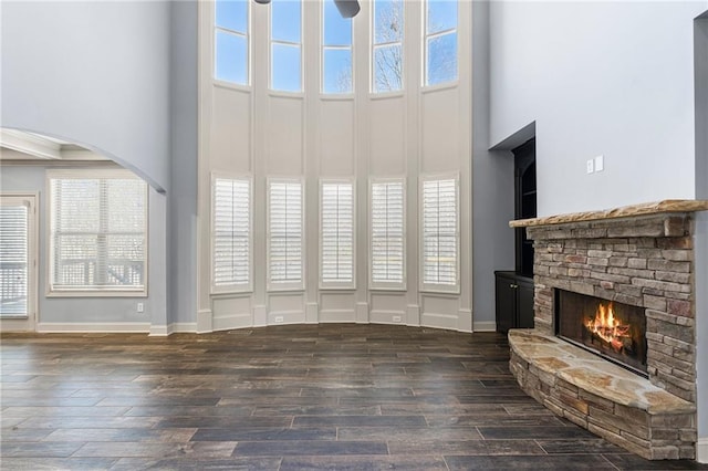 unfurnished living room with a fireplace and a towering ceiling