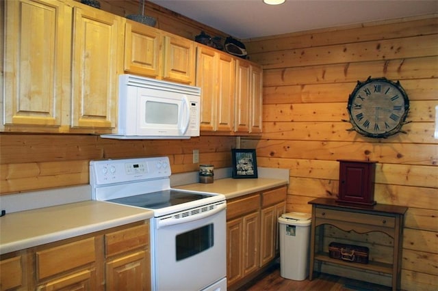 kitchen with white appliances, wood walls, and dark wood-type flooring