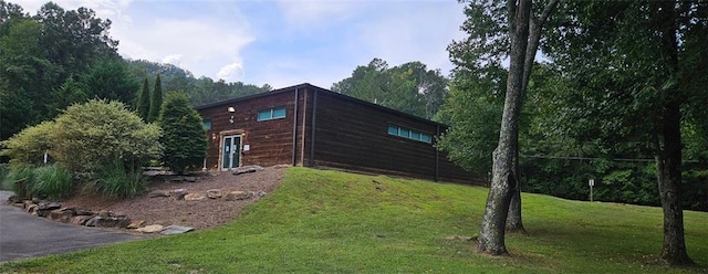 view of side of home with a yard