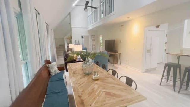 dining space with ceiling fan and a towering ceiling