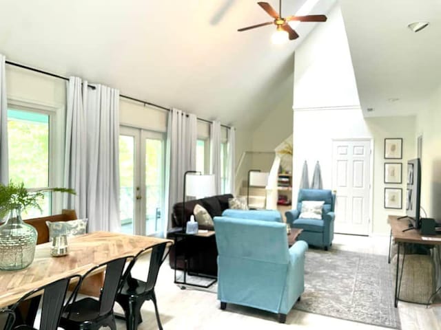 living room with french doors, light hardwood / wood-style floors, high vaulted ceiling, and ceiling fan