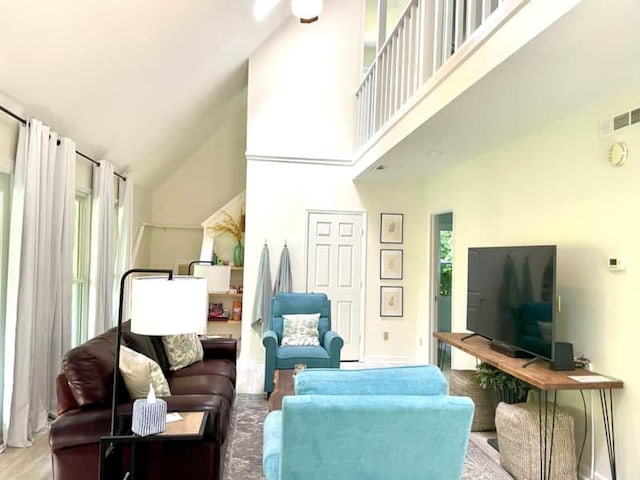 living room with light hardwood / wood-style floors, high vaulted ceiling, and ceiling fan