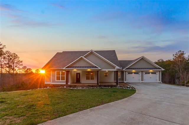 view of front of home featuring covered porch, an attached garage, driveway, and a front yard