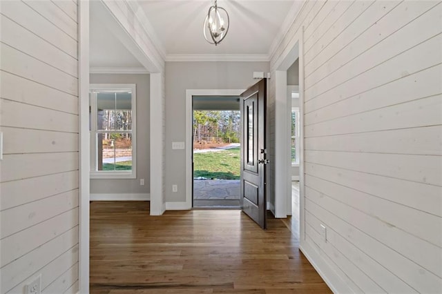 foyer with ornamental molding, baseboards, and wood finished floors