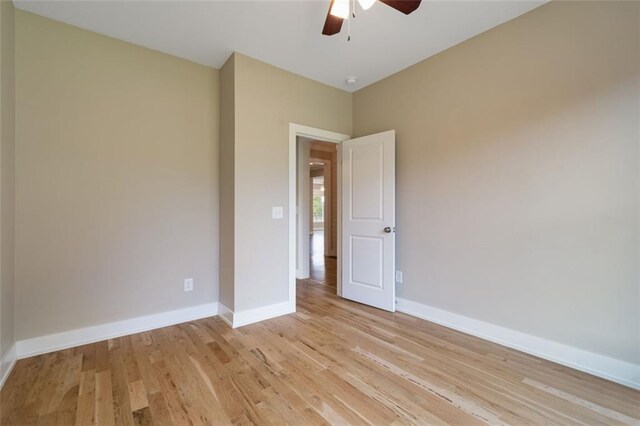 spare room with light wood-type flooring, baseboards, visible vents, and ceiling fan