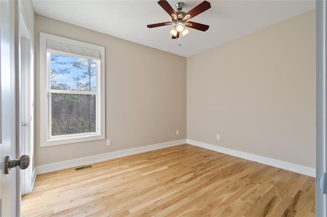 empty room featuring visible vents, baseboards, light wood-style floors, and a ceiling fan