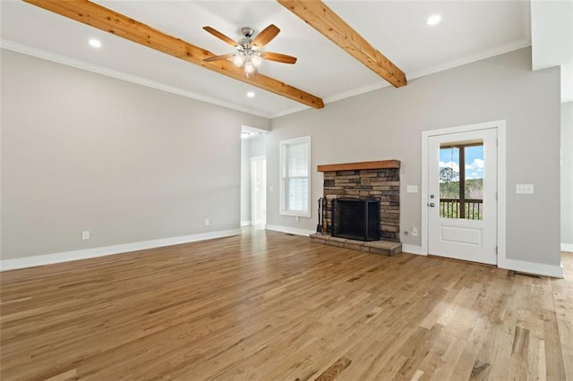 unfurnished living room featuring baseboards, light wood finished floors, beam ceiling, ceiling fan, and a stone fireplace