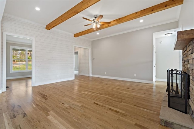 unfurnished living room with light wood-type flooring, beamed ceiling, a ceiling fan, a fireplace, and baseboards