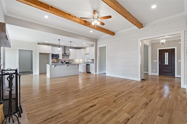 living area with beam ceiling, ornamental molding, a ceiling fan, recessed lighting, and light wood-style floors