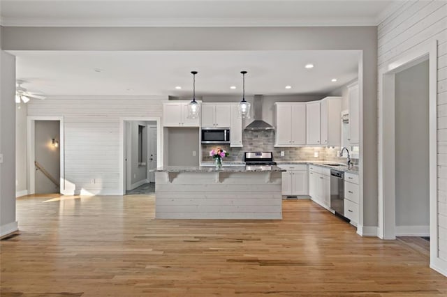 kitchen featuring light wood-style flooring, appliances with stainless steel finishes, white cabinetry, and wall chimney exhaust hood