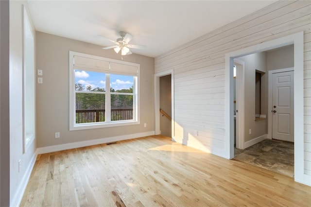 unfurnished room featuring ceiling fan, visible vents, baseboards, and wood finished floors