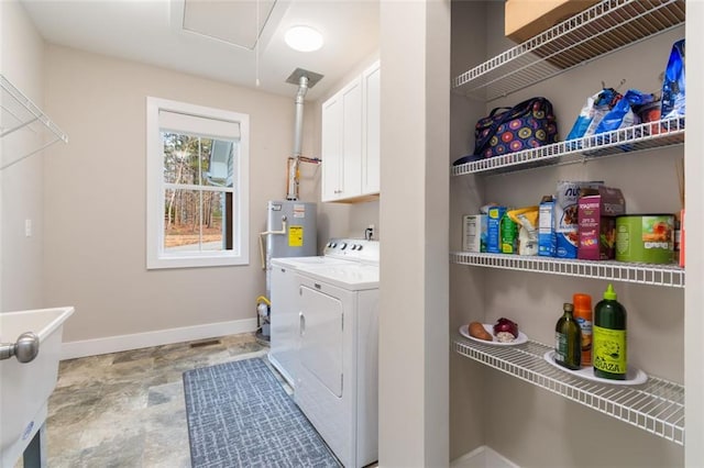 laundry room featuring separate washer and dryer, cabinet space, baseboards, and electric water heater