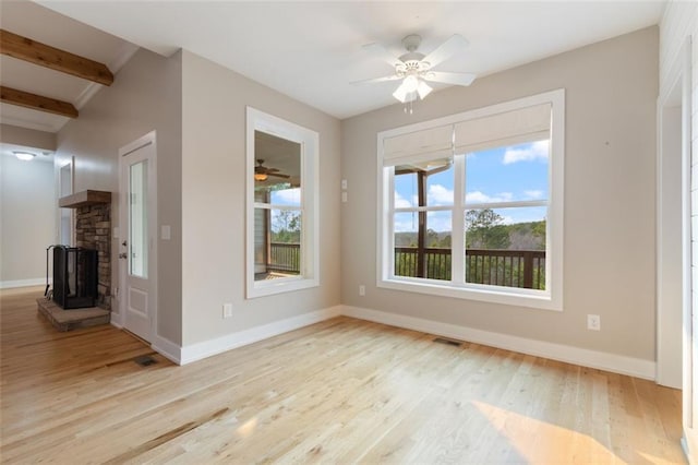 unfurnished living room with plenty of natural light, wood finished floors, and baseboards