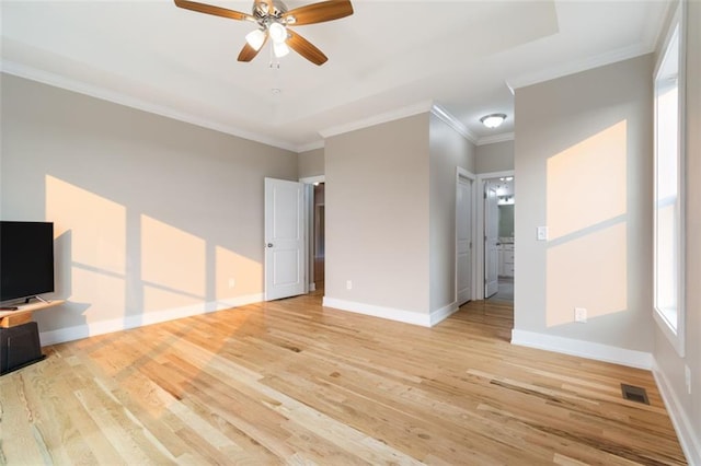 unfurnished living room with a ceiling fan, a tray ceiling, light wood-style floors, and baseboards