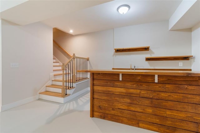 staircase featuring recessed lighting, concrete flooring, and baseboards