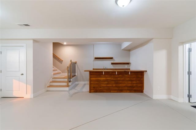 bar featuring visible vents, baseboards, concrete floors, and stairs