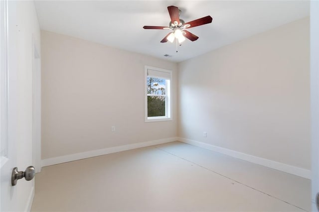 spare room featuring ceiling fan, concrete flooring, and baseboards