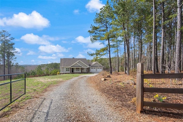 view of front facade featuring a gate, gravel driveway, and fence