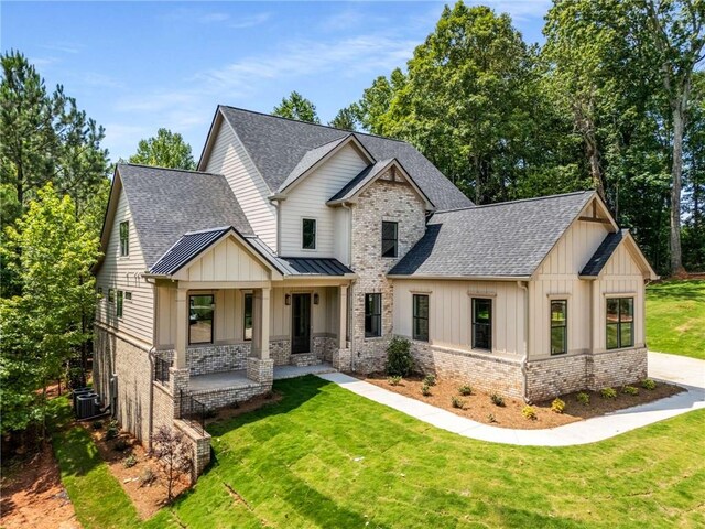 7262 Creekside Way, Jefferson, GA 30549 - view of front facade with covered porch, a shingled roof, board and batten siding, a front yard, and brick siding