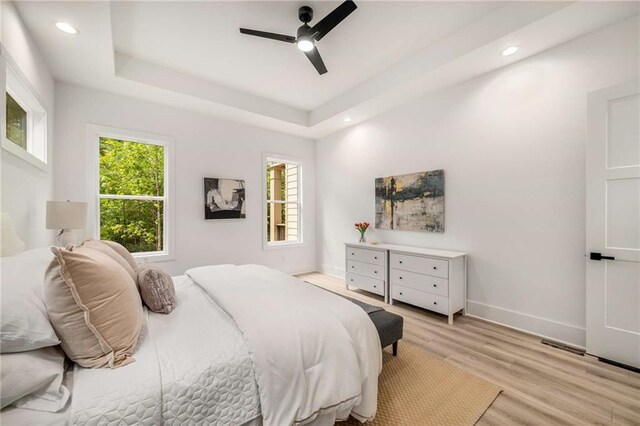 7262 Creekside Way, Jefferson, GA 30549 - bedroom with multiple windows, light wood-style flooring, recessed lighting, ceiling fan, and a tray ceiling