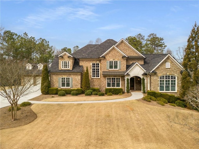 view of front of house featuring driveway and brick siding