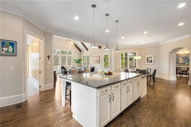 kitchen featuring white cabinetry, dark wood-type flooring, dark stone countertops, and ornamental molding