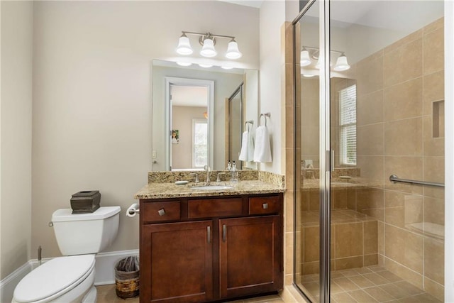 bathroom with a stall shower, vanity, and toilet