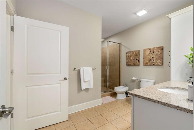 bathroom featuring tile patterned flooring, toilet, vanity, baseboards, and a shower stall