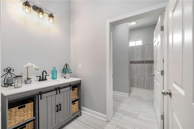 full bathroom featuring baseboards, walk in shower, and vanity