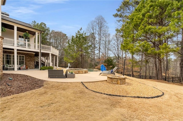 view of yard featuring an outdoor fire pit, fence, stairs, a wooden deck, and a patio area