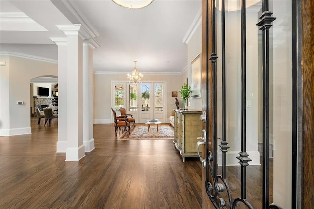 entryway with dark wood-style floors, a fireplace, decorative columns, ornamental molding, and baseboards