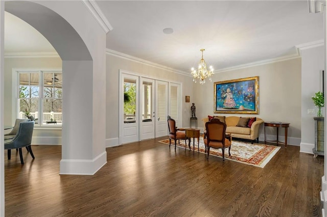 sitting room with a healthy amount of sunlight, baseboards, dark wood finished floors, and a notable chandelier