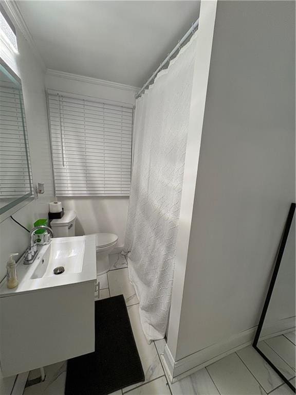 bathroom with ornamental molding, vanity, toilet, and curtained shower