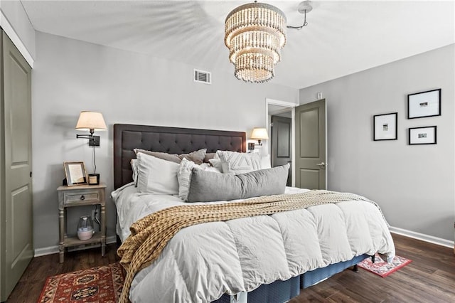 bedroom featuring dark hardwood / wood-style floors and an inviting chandelier