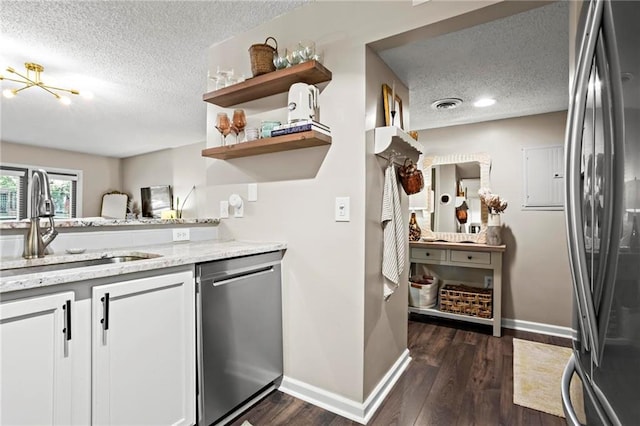 kitchen featuring sink, stainless steel appliances, dark hardwood / wood-style floors, a textured ceiling, and white cabinets