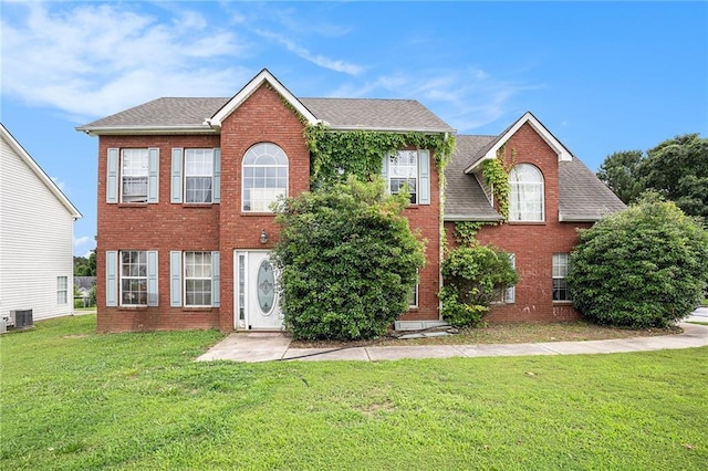 1135 Misty Meadows Way, Hampton, GA 30229 - colonial house featuring brick siding, a front yard, and roof with shingles