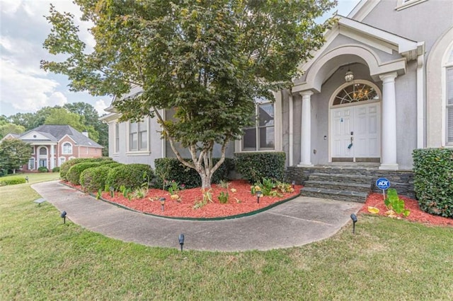 property entrance featuring a lawn