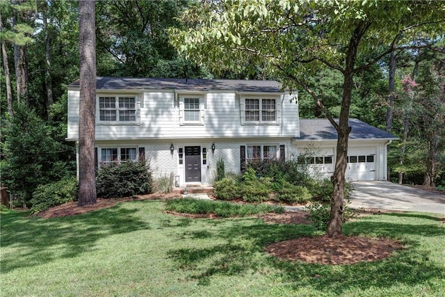 colonial home featuring a garage, concrete driveway, a front lawn, and brick siding