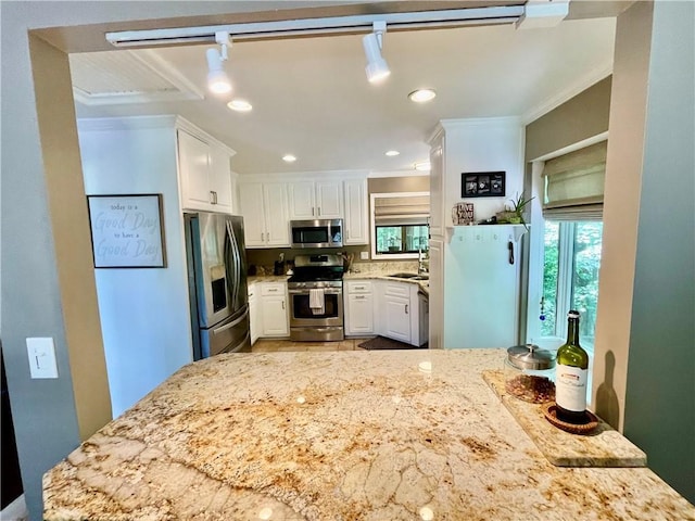 2694 Tritt Springs Dr NE, Marietta, GA 30062 - kitchen featuring appliances with stainless steel finishes, crown molding, a sink, white cabinets, and light stone counters