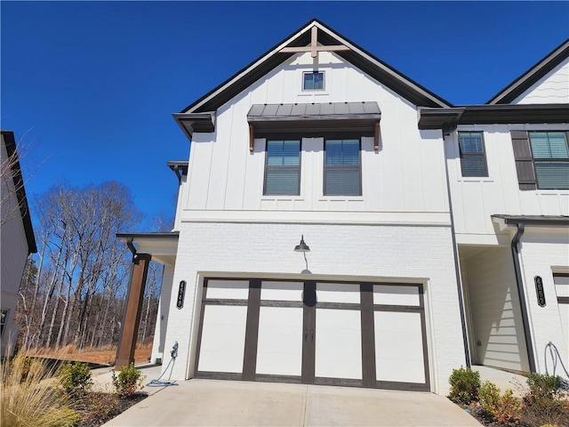 modern inspired farmhouse featuring a garage, a standing seam roof, board and batten siding, and concrete driveway