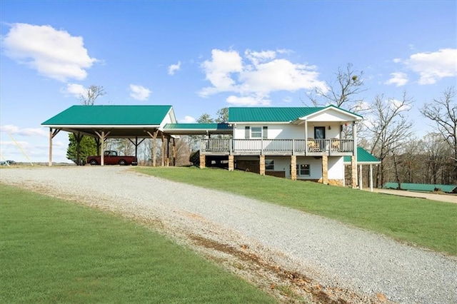 view of front of property with metal roof, gravel driveway, and a front yard