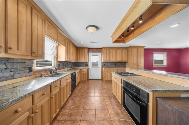 kitchen with light stone counters, light tile patterned floors, a sink, decorative backsplash, and black appliances