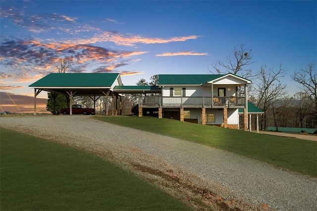 view of front of property with metal roof, driveway, a carport, and a front lawn