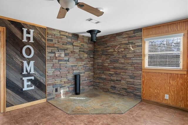 details with visible vents, wooden walls, and ceiling fan