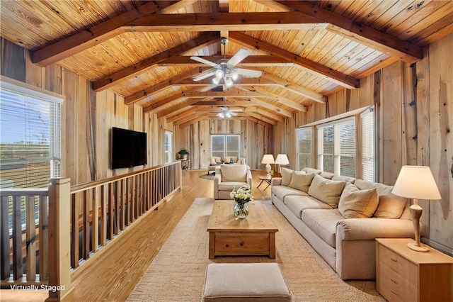 living area with wooden walls, wood finished floors, a ceiling fan, vaulted ceiling with beams, and wood ceiling