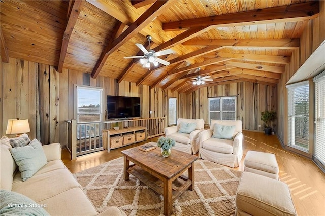 living area with wooden ceiling, light wood-style flooring, vaulted ceiling with beams, and wood walls