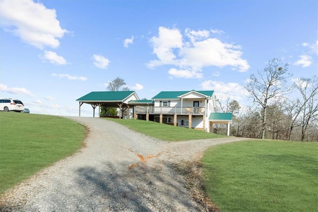 view of front of property featuring a carport, gravel driveway, and a front lawn