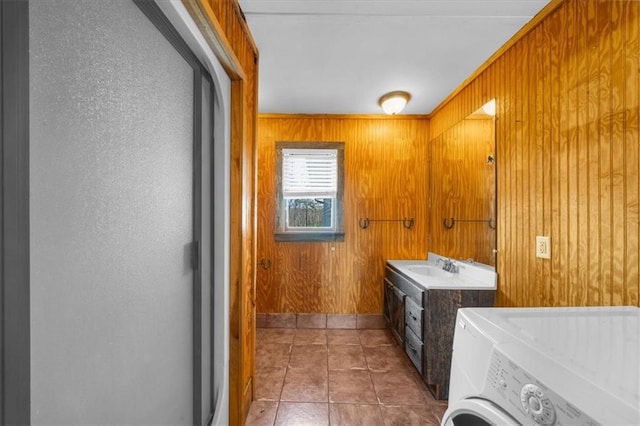 bathroom with tile patterned flooring, wooden walls, vanity, and separate washer and dryer