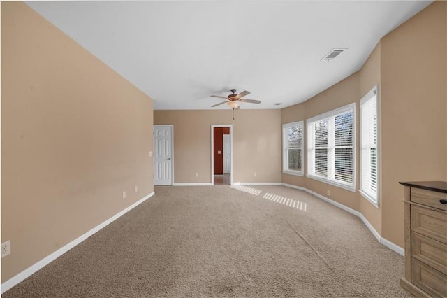 spare room with visible vents, ceiling fan, carpet, and baseboards