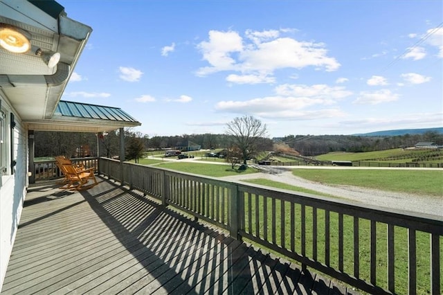 wooden terrace featuring a yard and a rural view